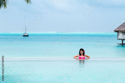 Beautiful young brunette in the infinity pool