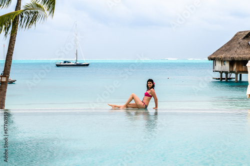 Beautiful young brunette in the infinity pool