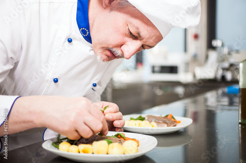 Schilderij op canvas Chef garnishing a dish