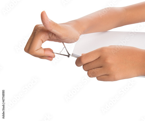 Female hand holding white paper with binder clips 