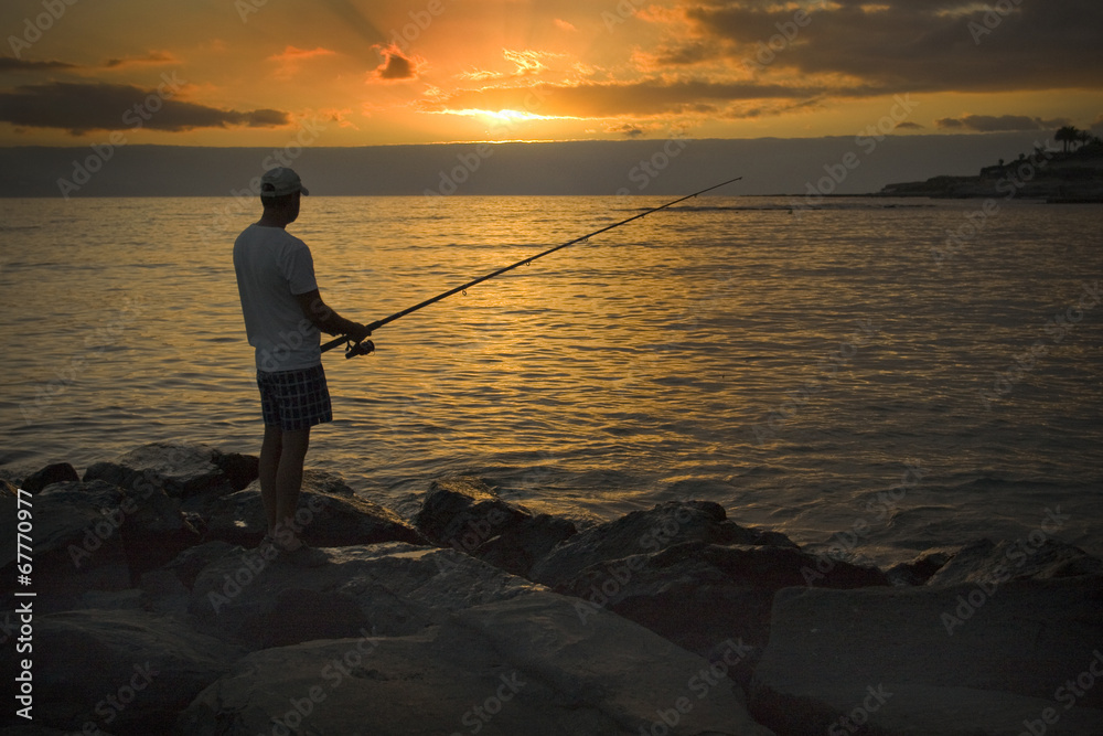 Fisherman on the shore of the ocean at sunset Fisherman on the shore of the ocean at sunset