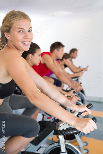 Blonde smiling at camera during spin class