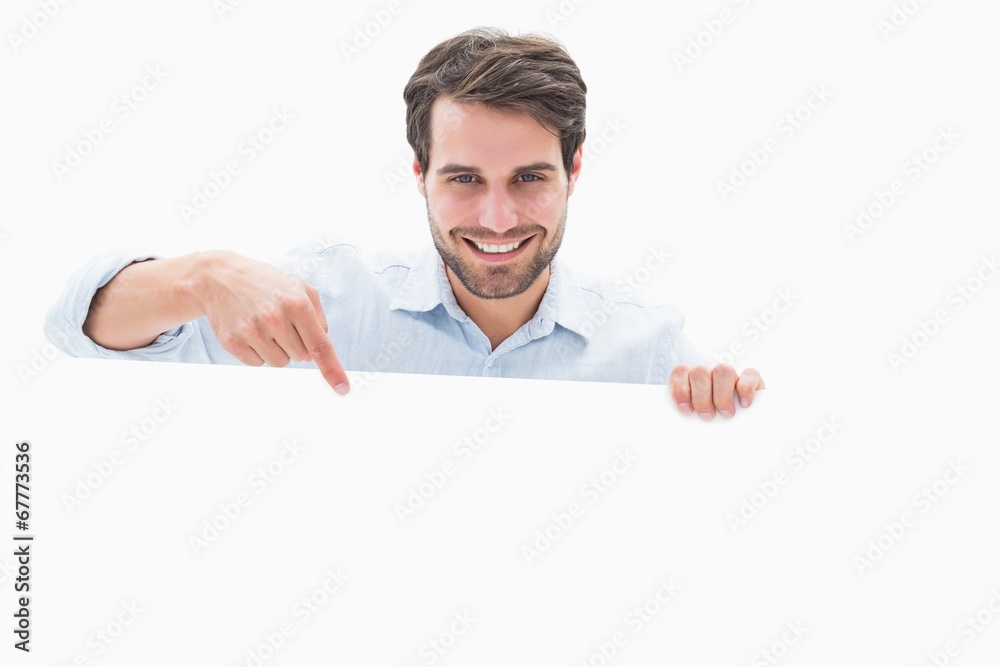 Attractive young man smiling and holding poster Attractive young man smiling and holding poster