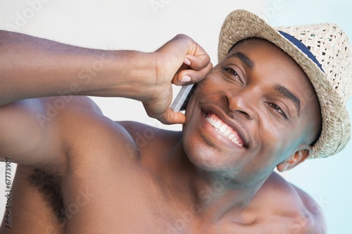Smiling man talking on phone by the pool