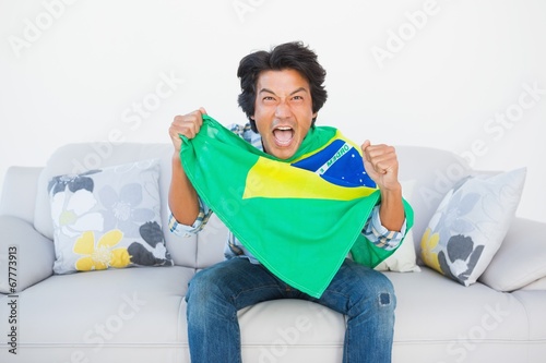Football fan cheering and holding brazil flag © WavebreakMediaMicro