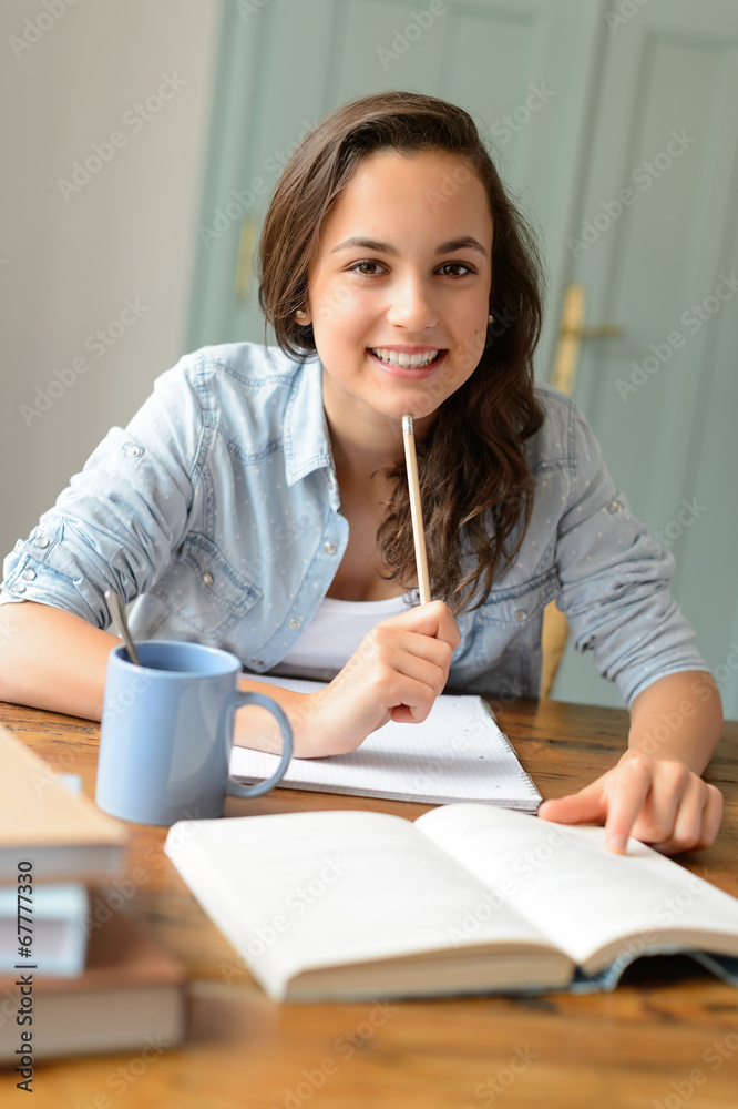 Student teenage girl studying at home smiling