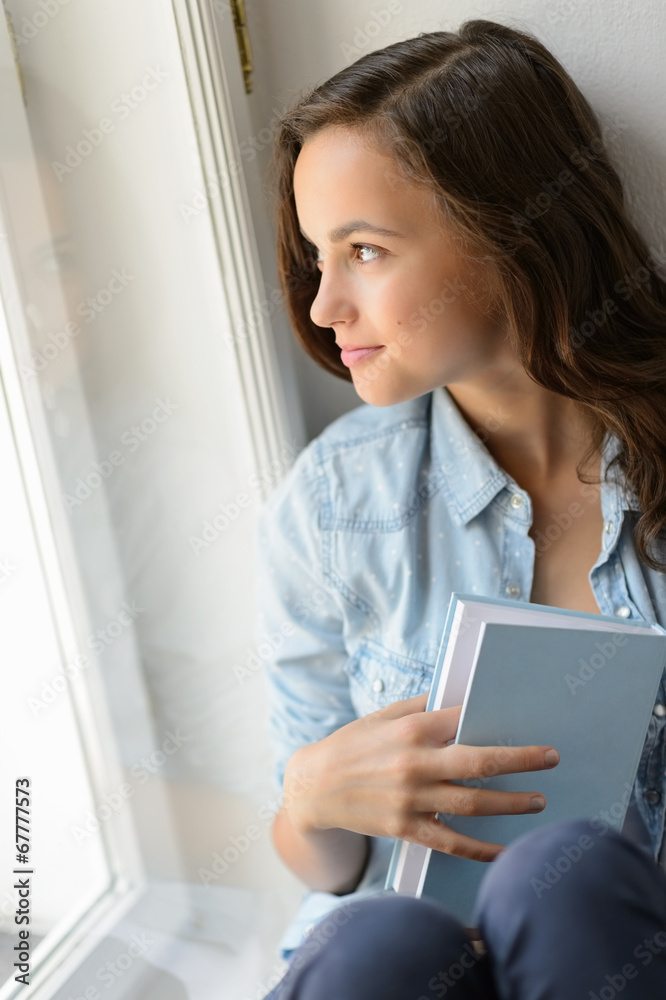 Beautiful teenage girl looking out the window Beautiful teenage girl looking out the window