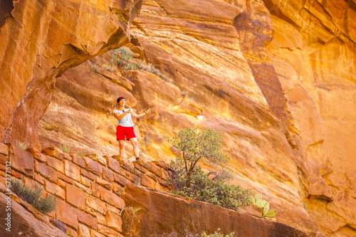 Tourist among red rocks in Zion National Park