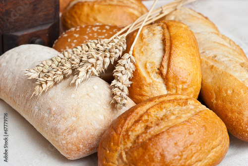 Freshly baked traditional rolls with ears of wheat grain