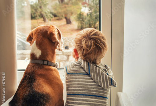 little boy with best friend looking through window