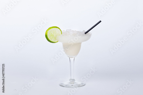 white cocktail with lime and ice crumbs