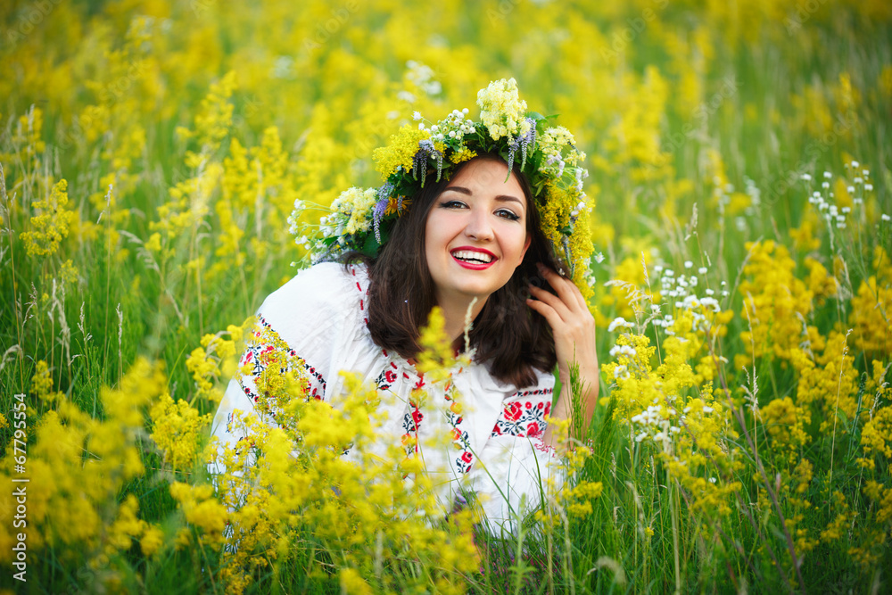 Young smiling girl in Ukrainian costume with a wreath on his hea Young smiling girl in Ukrainian costume with a wreath on his hea