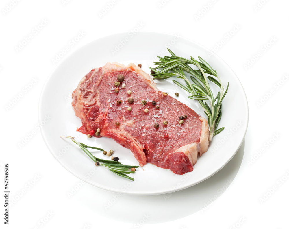 Raw sirloin steak with rosemary and spices on plate