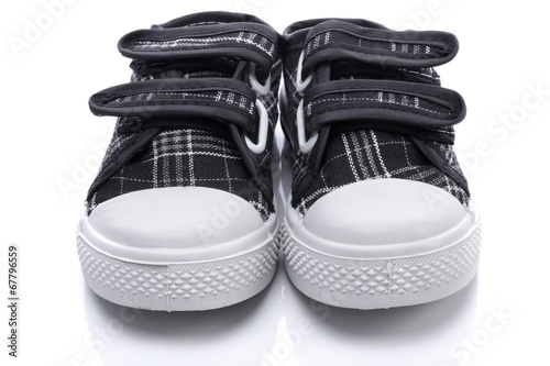 Black sneakers for a baby on white background