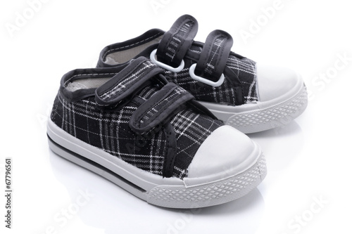 Black sneakers for a baby on white background