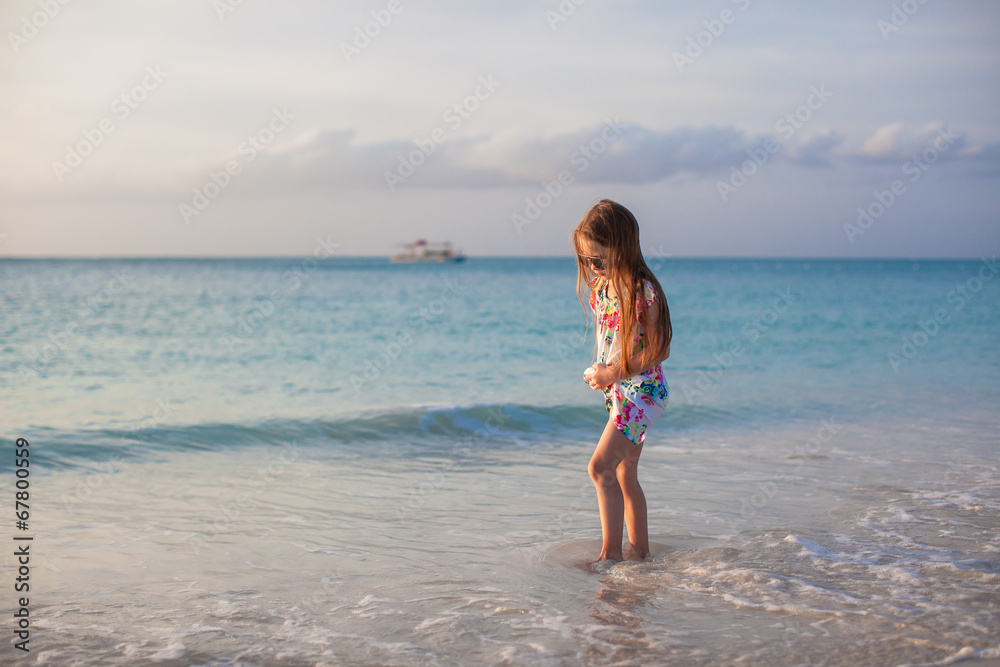 Adorable little girl walking at white tropical beach
