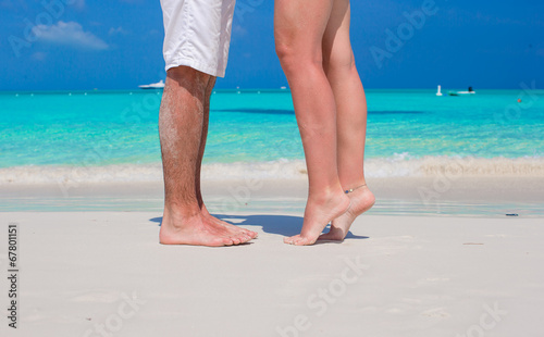 Close up male and female feet on white sand