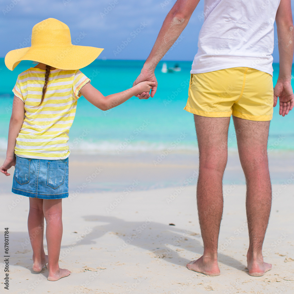Close up of little girl holding her father hand on the beach Close up of little girl holding her father hand on the beach