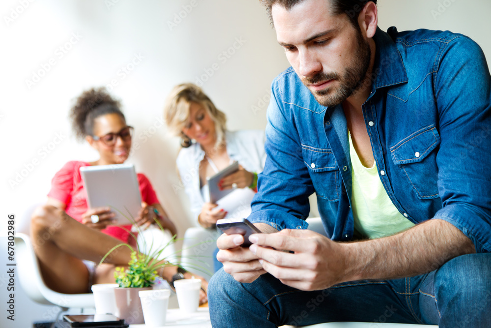 Young business man using his mobile phone, in the background bus