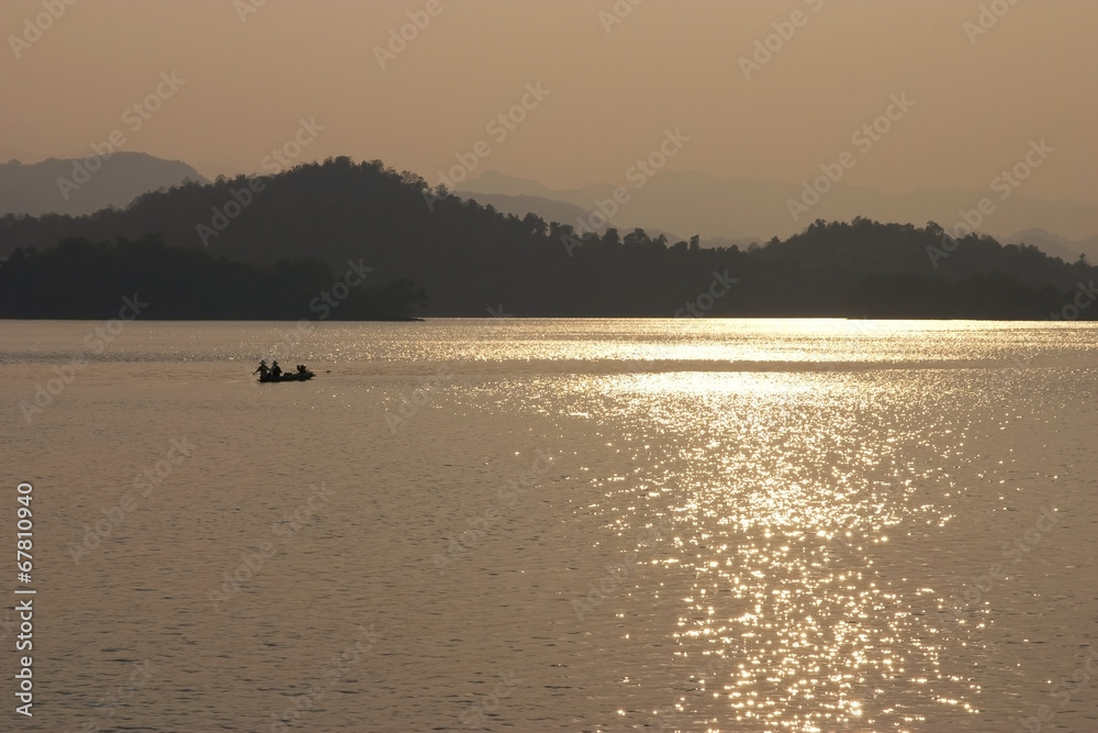 Traditional fishing in dam during sun set