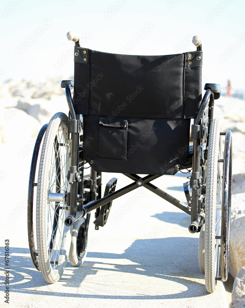 black wheelchair from behind with rubber wheels