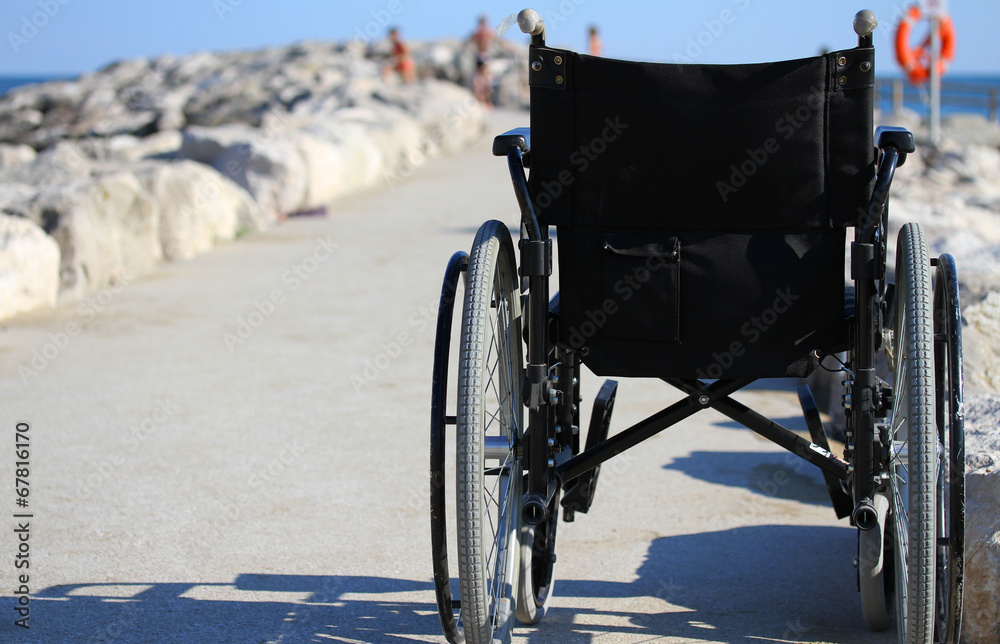 wheelchair from behind near the shore of the sea