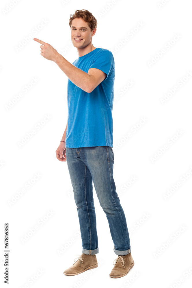 Smiling young man pointing to the side Smiling young man pointing to the side
