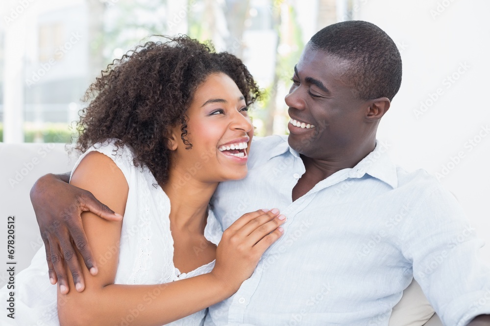 Attractive mixed race couple cuddling on the couch Attractive mixed race couple cuddling on the couch