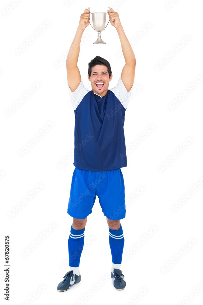 Football player in blue holding winners cup Football player in blue holding winners cup