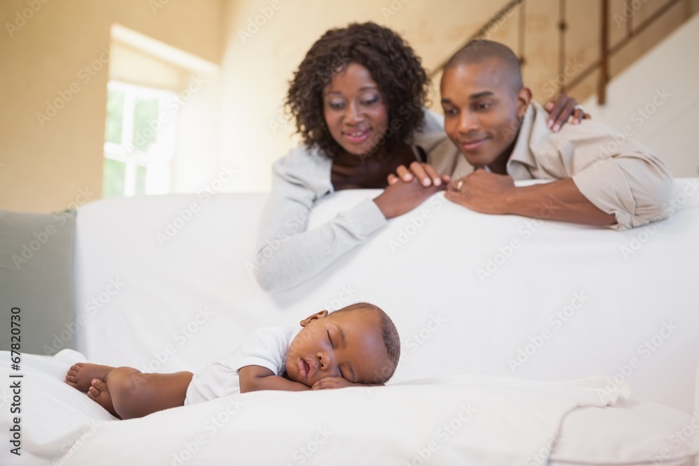 Baby boy sleeping peacefully on couch watched by parents Baby boy sleeping peacefully on couch watched by parents