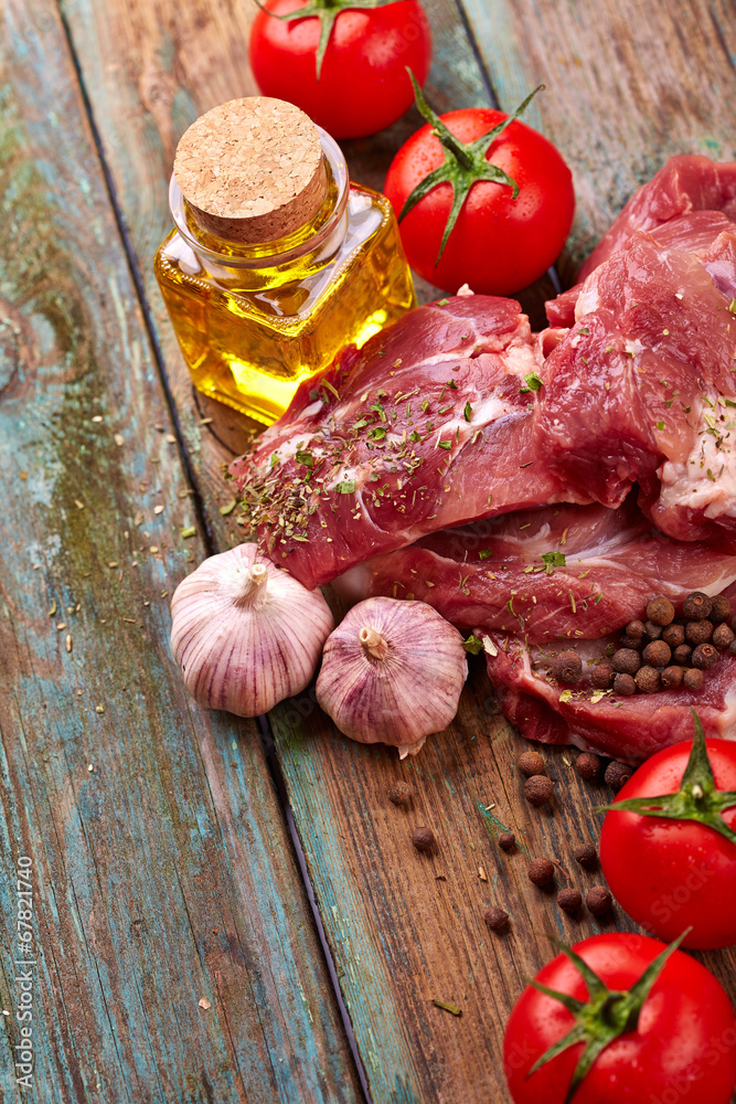 Raw steak with tomatoes over wooden background Raw steak with tomatoes over wooden background