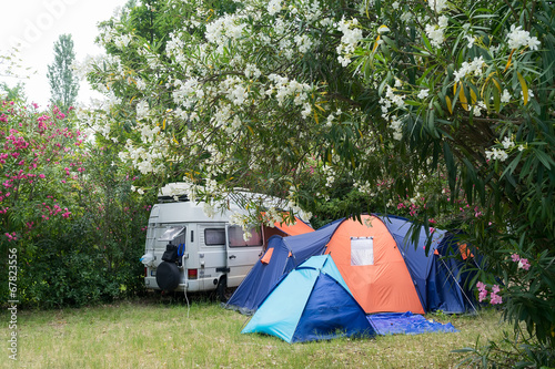 Campsite with caravan and tent in summertime.