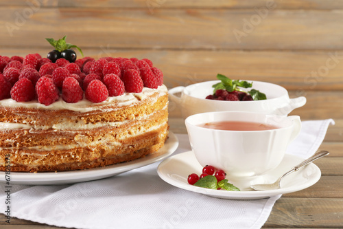 Tasty cake with fresh berries on wooden table