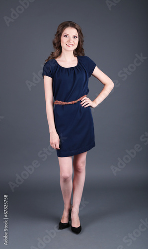 Beautiful young girl in dress on grey background © Africa Studio