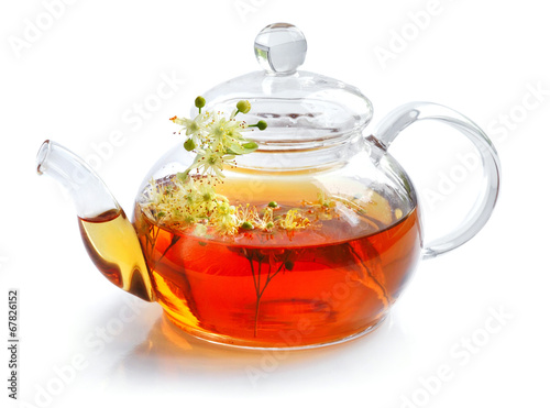 Teapot with linden tea and flowers on white background