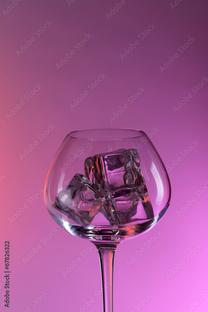 Glass with ice cubes on color background Glass with ice cubes on color background
