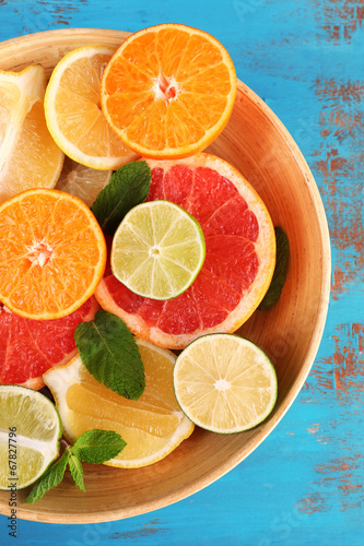 Fototapeta Naklejka Na Ścianę i Meble -  Different sliced juicy citrus fruits in bowl