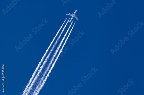 Bild auf Leinwand A long trail of jet plane on blue sky