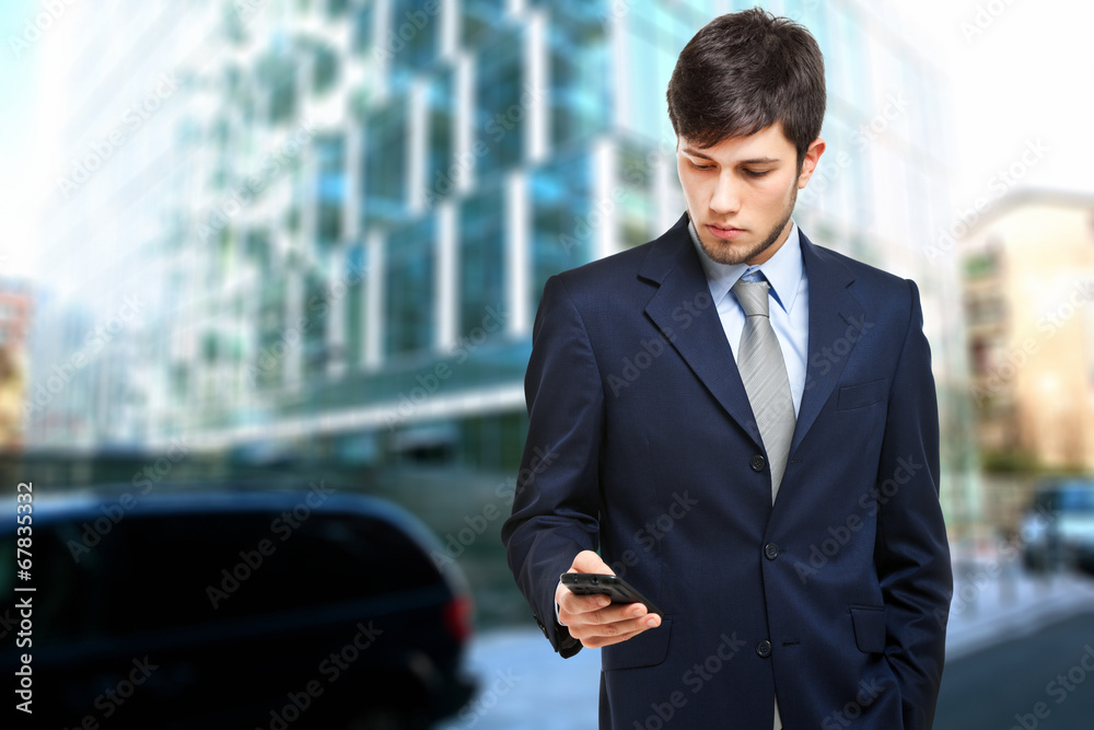 Handsome young man sending a sms Handsome young man sending a sms