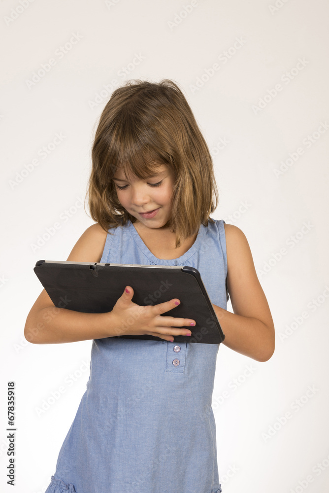 Little girl playing with a digital tablet Little girl playing with a digital tablet