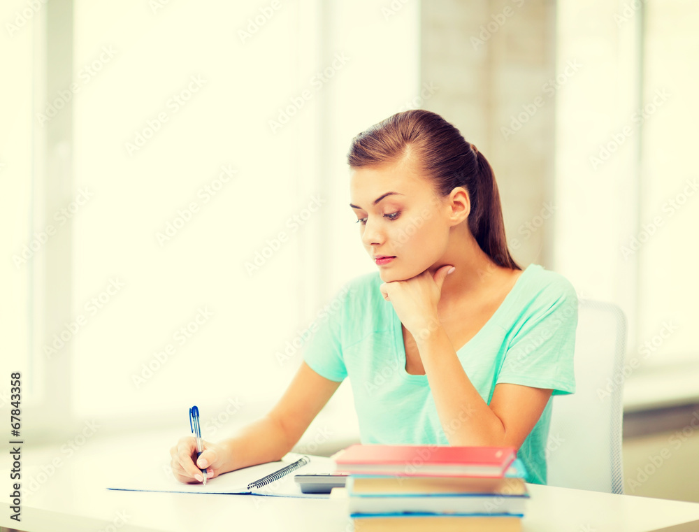 tired student writing in notebook tired student writing in notebook
