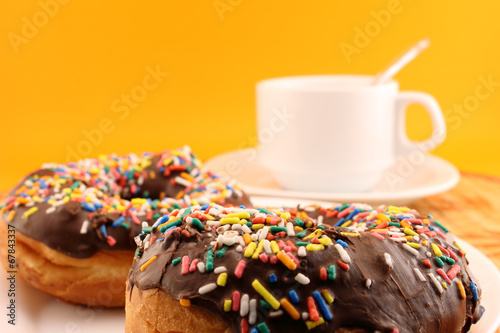 Chocolate donuts with sprinkles and coffee cup