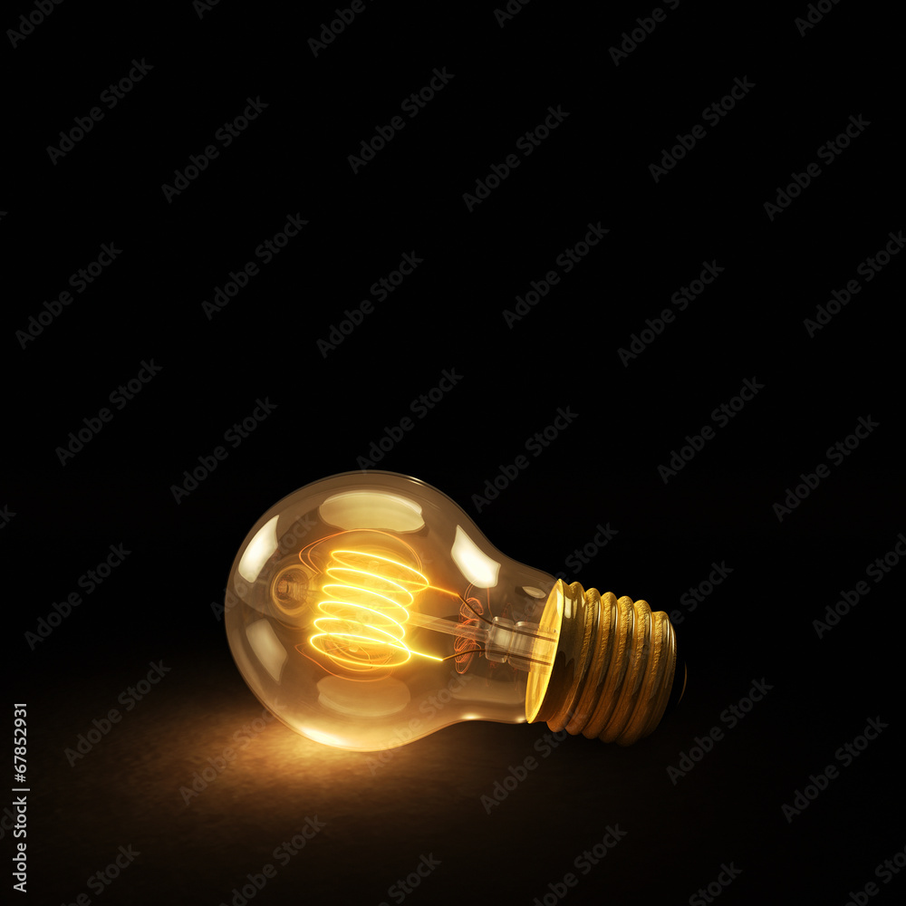 Glowing Incandescent Light Bulb on a Dark Background Glowing Incandescent Light Bulb on a Dark Background