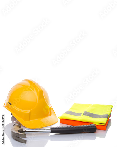 Yellow hard hat, a hammer and orange and yellow reflective vest  photo