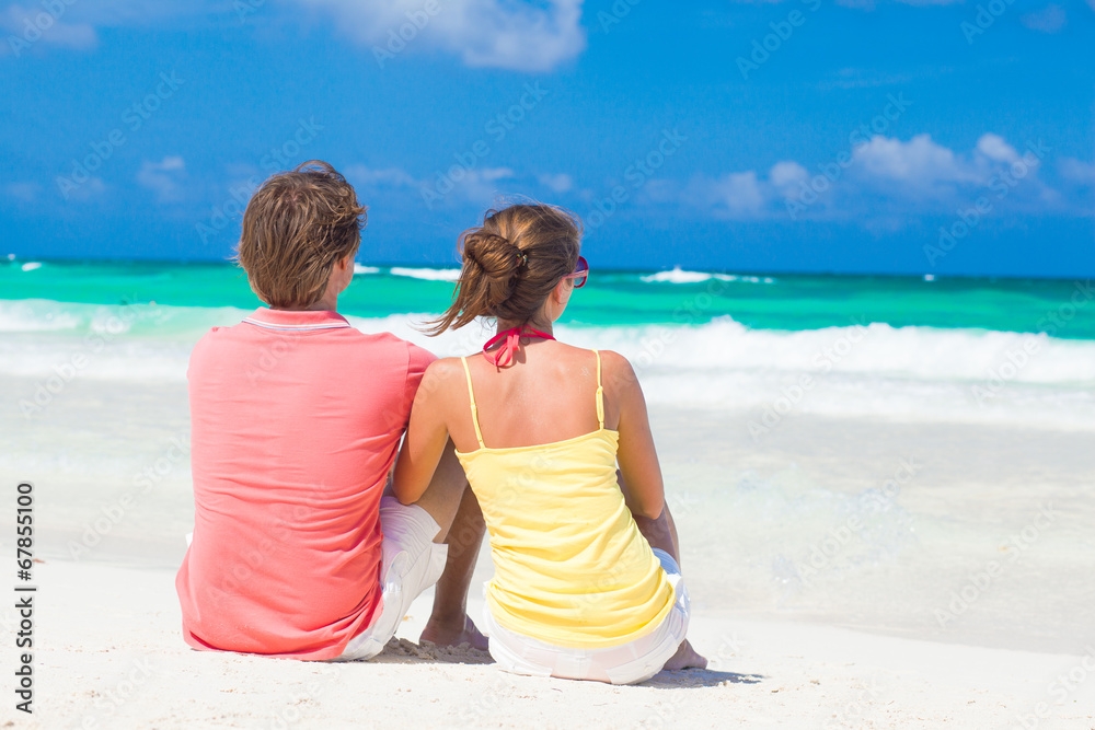 Fototapeta premium happy young couple sitting at beach