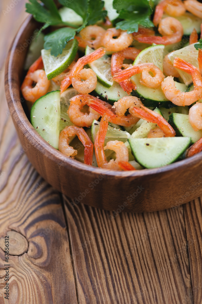 Wooden bowl with shrimps, cucumber and lime salad, vertical shot Wooden bowl with shrimps, cucumber and lime salad, vertical shot