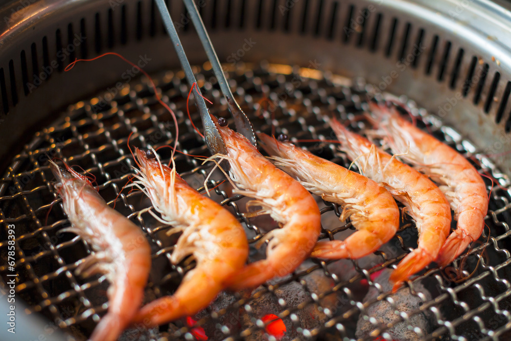 chef grilling shrimps on flame with tongs chef grilling shrimps on flame with tongs