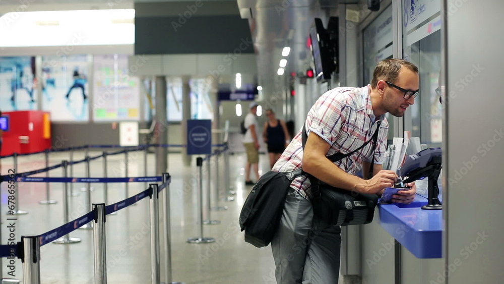 Man asking for info at info kiosk in train terminal Man asking for info at info kiosk in train terminal