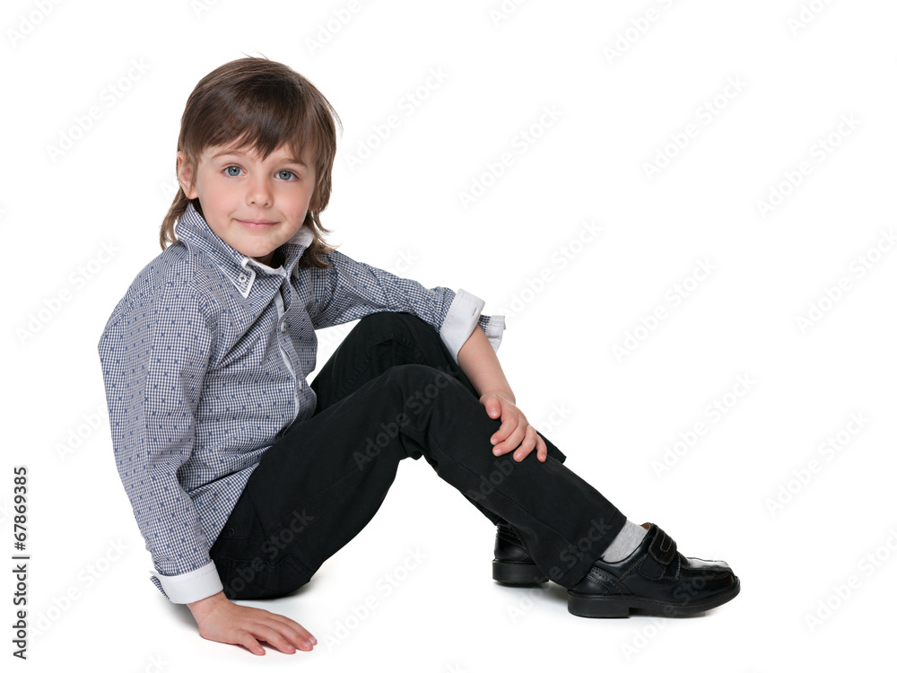 Fashion little boy sitting on the floor