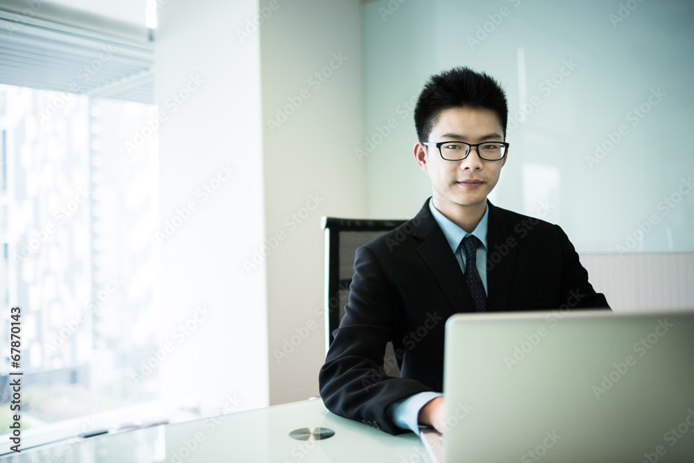 Young handsome man using laptop in his office Young handsome man using laptop in his office